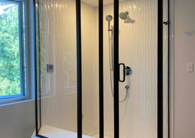 Groutless tile in vertical wave tile for a steam shower black semi frameless shower enclosure