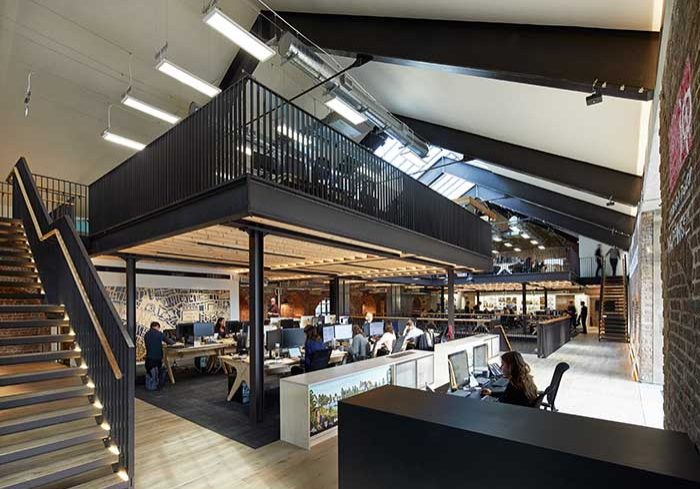 Modern commercial interior space featuring open workstations, a mezzanine level, and collaborative areas, reflecting innovative design trends influencing residential renovations in Langley and Surrey.