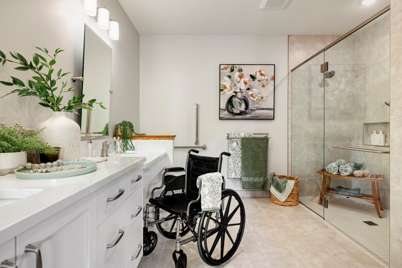Accessible bathroom design featuring a wheelchair, grab bars, and modern fixtures, highlighting considerations for mobility challenges and aging family members.